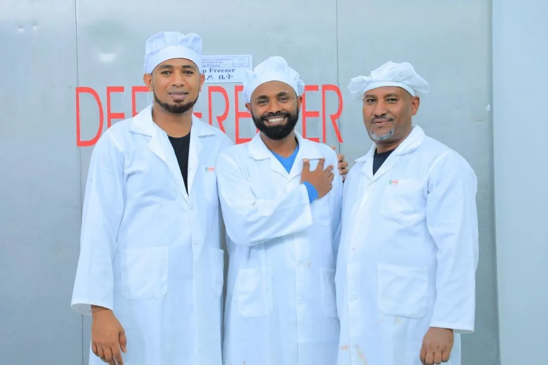 Al Nujum staff in white coats and hairnets at the facility